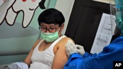 Un trabajador de salud inyecta una vacuna de coronavirus a un voluntario en un centro médico comunitario en Bandung, West Java, Indonesia, el viernes 14 de agosto de 2020.