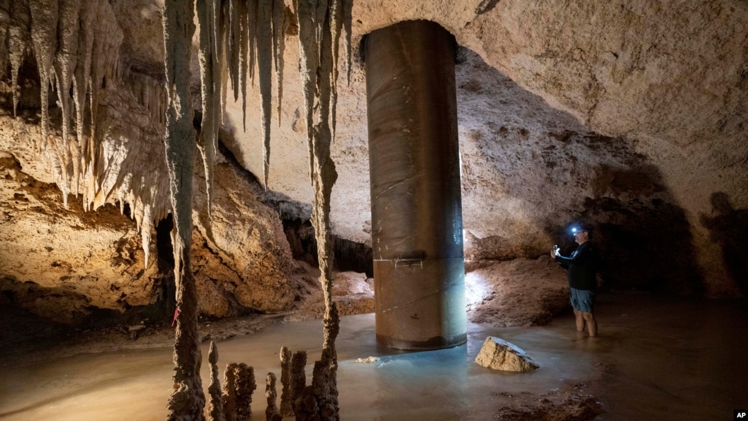 Engineer Guillermo D. Christy photographs a steel pillar filled with concrete that was installed inside the Aktun Tuyul cave system to support the Maya Train track on the outskirts of Playa del Carmen, Mexico, March 3, 2024. 