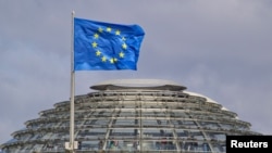 The European Union flag is seen above the cupola of the Reichstag building, the seat of the Bundestag in Berlin, April 2, 2012. 