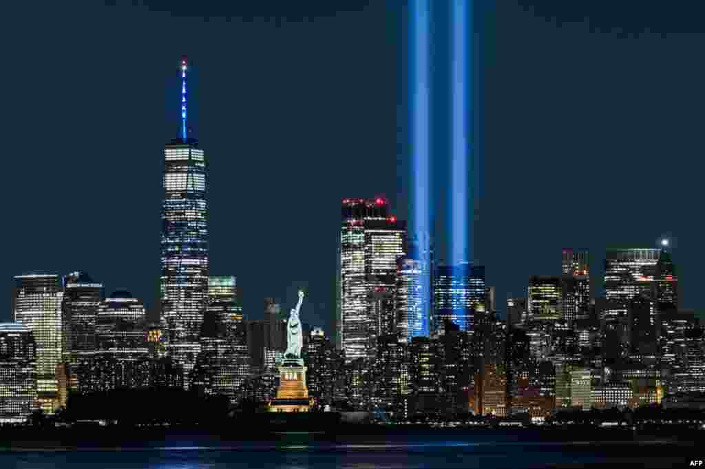 The Statue of Liberty shines near the Tribute in Light as part of the commemoration for 20th anniversary of the terrorist attack in New York City, Sept. 11, 2021.