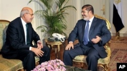 FILE - Nobel Peace Prize winner and one of the leaders of the National Salvation Front, Mohamed ElBaradei (L), meets with Egyptian President Mohammed Morsi, in Cairo, Egypt, November 2012.
