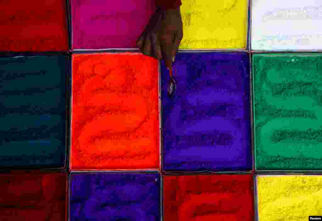 A street vendor spreads vermilion powder used for worship during the Tihar festival, also called Diwali, in Kathmandu, Nepal.