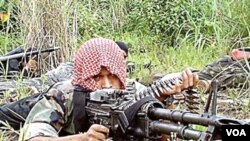 Seorang tentara pemberontak Moro dengan senjata mesin M60.