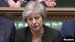 Britain's Prime Minister Theresa May listens as Jeremy Corbyn speaks in Parliament, London, Jan. 29, 2019.