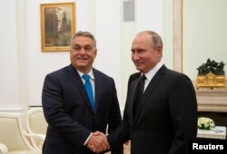 Presiden Rusia Vladimir Putin (kanan) menjabat PM Hungaria Viktor Orban dalam pertemuan di Kremlin, Moskow, Rusia (foto: dok).