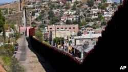 FILE - The international border cuts through Nogales, Sonora, Mexico, right, and Nogales, Arizona, as seen April 9, 2018, from Nogales. 