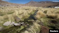 FILE - Water runs in one of the springs in Silala, south of La Paz, March 29, 2016. Chile on Monday filed a lawsuit against neighbor Bolivia, which has long insisted that it should be compensated for use of water flowing down the Silala River into Chile.