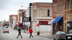  Local residents walk across Main Street, Friday, Jan. 27, 2017, in Ottumwa, Iowa.Far from the cacophony enveloping Washington in President Donald Trump's first week in office, the Iowa voters who helped him capture the state and the presidency last November give the president high marks for reversing eight years of Democrat Barack Obama's policies.