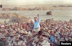 Tổng thống George H. W. Bush vẫy chào tạm biệt các Thủy quân lục chiến Mỹ và binh sĩ Anh khi kết thúc một chuyến thăm nhân ngày Lễ Tạ ơn trong sa mạc ở Ả-rập Saudi, ngày 22 tháng 11, 1990..