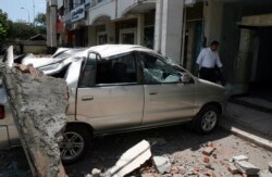 Sebuah minivan tertimpa bongkahan beton yang jatuh dari gedung setelah gempa mengguncang Bali, 13 Oktober 2011. (Foto: REUTERS/Zul Eduardo)