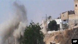 This image made from amateur video released by the Shaam News Network and accessed Wednesday, June 20, 2012, purports to show smoke rising from buildings in Homs province, Syria.