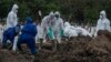 Des travailleurs déplacent un cercueil vers un site d'inhumation des victimes du coronavirus au cimetière de Keputih à Surabaya, en Indonésie, le 15 juillet 2020. (Photo by Juni Kriswanto / AFP)