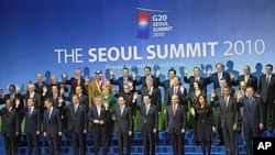 Members of the G20 wave during the family photo session at the G20 Summit in Seoul. Leaders of the world's 20 biggest economies faced the urgent task at their summit Friday of resolving a U.S.-China currency dispute that has raised the specter of a global