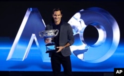Defending men's champion Switzerland's Roger Federer holds the Norman Brookes Challenge Cup during a photo opportunity at the official draw ceremony ahead of the Australian Open tennis championships in Melbourne, Australia, Thursday, Jan. 10, 2019. (AP Ph