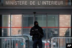 A police officer stands guard in front of the central office for the fight against corruption, financial and fiscal crime (OCLCIFF) where former French President Nicolas Sarkozy was held, in Nanterre, outside Paris, March 21, 2018.