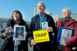 Survivors Network of those Abused by Priests (SNAP) President Tim Lennon from Tucson, Ariz., center, and SNAP members Esther Hatfield Miller from Los Angeles, left, and Carol Midboe from Austin, speak to the media in St. Peter's Square, Feb. 20, 2019.