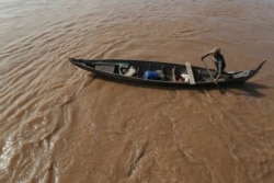 A Cambodian Muslim man rows his wooden boat where he lives along the Mekong River bank at a fisherman floating village located in Kball Chroy, near Phnom Penh, Cambodia, on Monday, Sept. 9, 2019. (AP Photo/Heng Sinith)