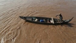 A Cambodian Muslim man rows his wooden boat where he lives along the Mekong River bank at a fisherman floating village located in Kball Chroy, near Phnom Penh, Cambodia, on Monday, Sept. 9, 2019. (AP Photo/Heng Sinith)