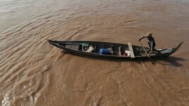 A Cambodian Muslim man rows his wooden boat where he lives along the Mekong River bank at a fisherman floating village located in Kball Chroy, near Phnom Penh, Cambodia, on Monday, Sept. 9, 2019. (AP Photo/Heng Sinith)