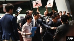 Hong Kong's Chief Executive Carrie Lam (2nd L) leaves the chamber for a second time while trying to give her annual policy address as she is heckled by pro-democracy lawmakers (at background) at the Legislative Council (Legco) in Hong Kong on October 16, 