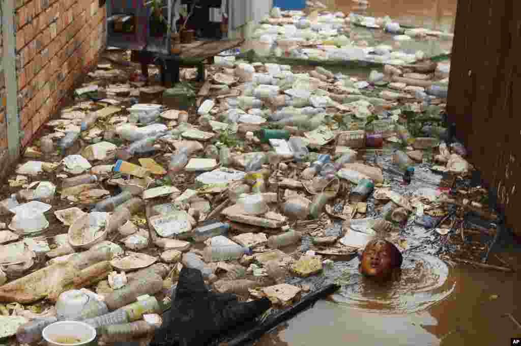 A boy swims in the floating village on the Mekong river bank on the outskirts of Phnom Penh, Cambodia, Aug. 11, 2018.