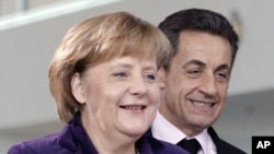 French President Nicolas Sarkozy (R) and German Chancellor Angela Merkel arrive for a news conference following their talks at the Chancellery in Berlin January 9, 2012