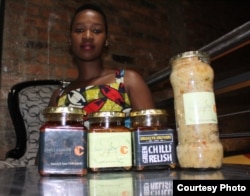 Farmer Leeko Nkala shows off a few of the sauces she produces from chili crops grown in South Africa's North West Province.