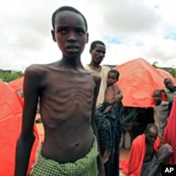 An internally displaced Somali family stand in front of their makeshift shelter in south Mogadishu in Hodan district.