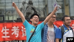A student pose for a photo after taking the 2014 college entrance exam of China, or the "gaokao", outside a high school in Beijing, June 8, 2014. 