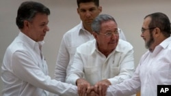 Cuba's President Raul Castro (Center) encourages Colombian President Juan Manuel Santos (Left) and Commander the Revolutionary Armed Forces of Colombia or FARC, Timoleon Jimenez, to shake hands, in Havana, Cuba, Sept. 23, 2015.