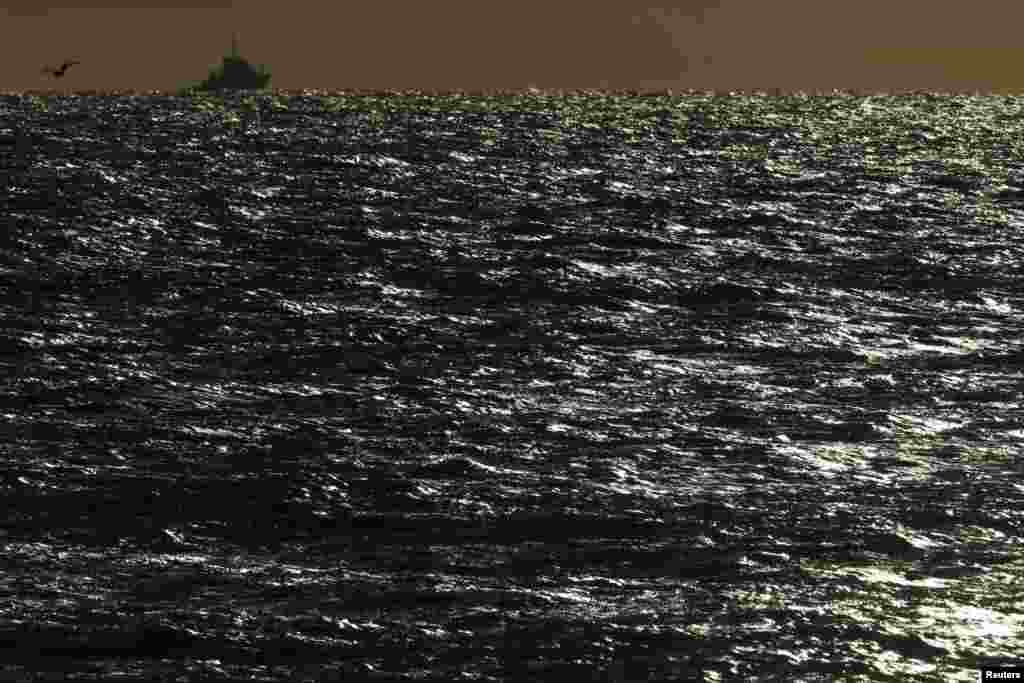 French towing boat "Abeille Languedoc" is silhouetted in the open sea near Boulogne-sur-Mer as high winds battered northern France, Nov. 4, 2013.