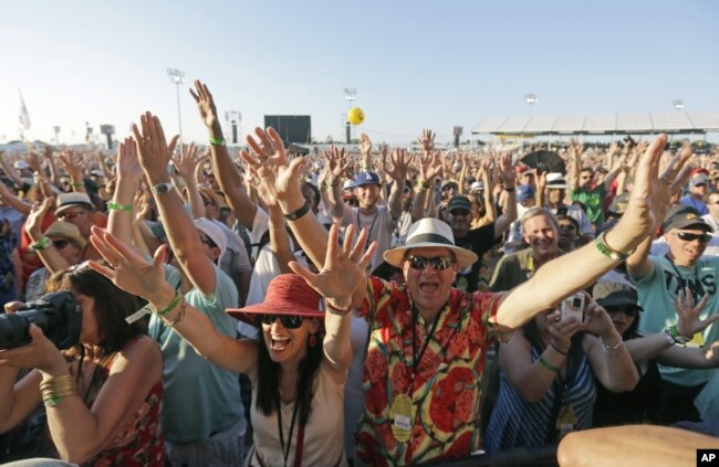 Festival-goers cheer at the New Orleans Jazz and Heritage Festival in New Orleans, Sunday, May 3, 2015.