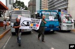 Transportation union members hold a work stoppage to protest the government of President Nicolas Maduro, a former bus driver, as they carry a sign that reads in Spanish "Transportation united for Venezuela," in Caracas, Venezuela, May 9, 2019.