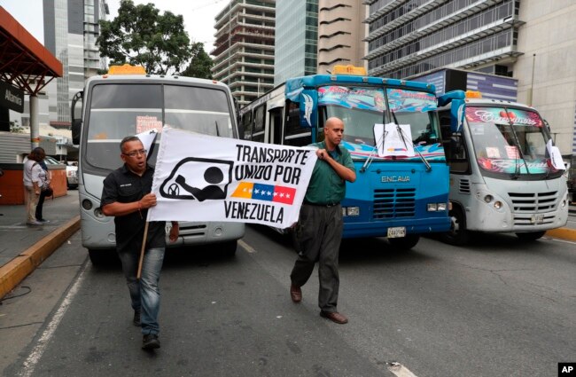 Transportation union members hold a work stoppage to protest the government of President Nicolas Maduro, a former bus driver, as they carry a sign that reads in Spanish "Transportation united for Venezuela," in the Altamira neighborhood of Caracas.