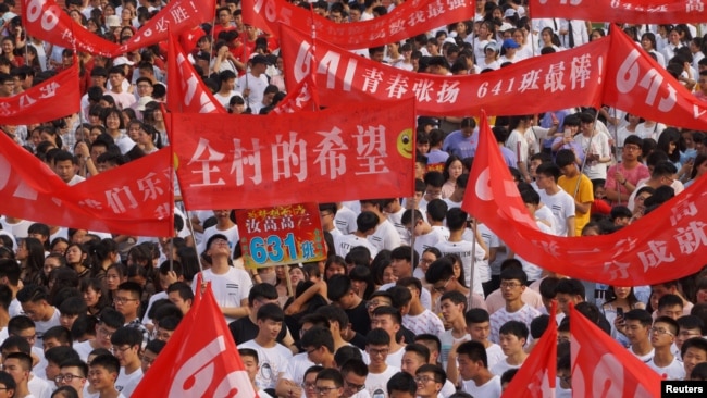 2018年6月3日,高考之前,中国河南省驻马店一所高中的毕业典礼上,学生打出的标语有“全村的希望”“青春张扬”“数我最强”。