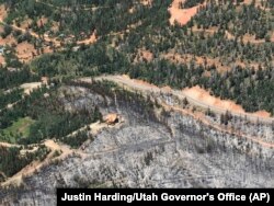 A saved cabin is shown in a burnout area near Brian Head, Utah, during a wildfire tour by Utah Lt. Gov. Spencer Cox, in southern Utah, June 27, 2017.