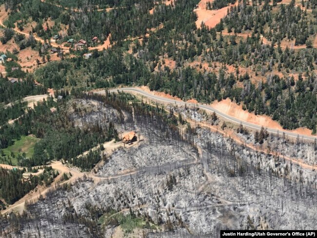 A saved cabin is shown in a burnout area near Brian Head, Utah, during a wildfire tour by Utah Lt. Gov. Spencer Cox, in southern Utah, June 27, 2017.