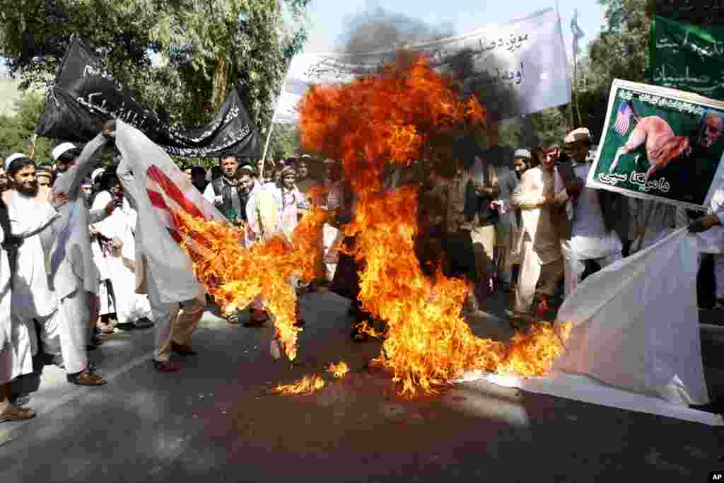 Afghan university students burn a U.S. flag in the Surkhrod district of Nangarhar province, Afghanistan, September 19, 2012. 