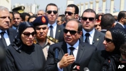 In this picture taken June 30, 2015, and provided by the office of the Egyptian Presidency, Egyptian president Abdel-Fattah el-Sissi (C) speaks at the funeral for Hisham Barakat, surrounded by the latter's family members.
