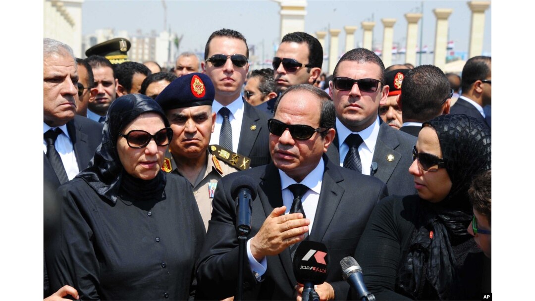 In this picture taken June 30, 2015, and provided by the office of the Egyptian Presidency, Egyptian president Abdel-Fattah el-Sissi (C) speaks at the funeral for Hisham Barakat, surrounded by the latter's family members.