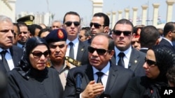 In this picture taken June 30, 2015, and provided by the office of the Egyptian Presidency, Egyptian president Abdel-Fattah el-Sissi (C) speaks at the funeral for Hisham Barakat, surrounded by the latter's family members.