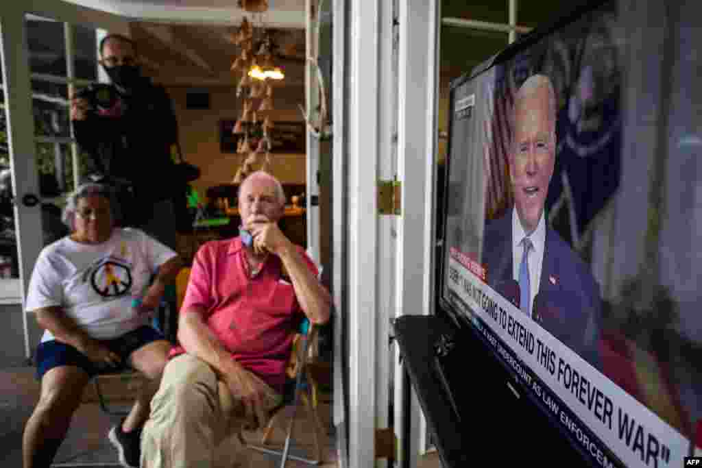 ایک فوجی خاندان کے افراد افغانستان سے امریکی آپریشن مکمل کرنے سے متعلق صدر بائیڈن کے خطاب کو سن رہے ہیں۔