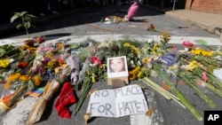 A makeshift memorial of flowers and a photo of victim, Heather Heyer, sits in Charlottesville, Virginia, Aug. 13, 2017. 