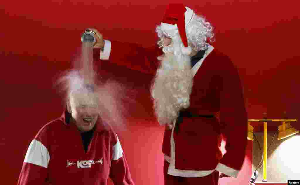 Ivan Timofeenko, co-founder of &quot;Newton Park,&quot; a private interactive museum of science, dressed as Santa Claus, pours liquid nitrogen, bearing the temperature of about -196&ordm; C(- 320.8&ordm; F), on the head of visitor Dmitry Shilov during the &quot;Arctic&quot; scientific show for school children at the &quot;Square of Peace&quot; museum center in the Siberian city of Krasnoyarsk, Russia.