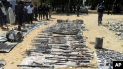 Wani dan sanda yana duba gine gine da ababan hawa da kuma makamai bayan harin da kungiyar Boko Haram ta kai a Damaturu ranar 25 da 25 ga watan Oktoba. An dauki hotunan ranar 28 ga watan Oktoba, 2013.