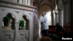 FILE - A woman prays at Sheshan Cathedral in the outskirts of Shanghai October 28, 2013. Picture taken on October 28, 2013.