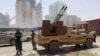 FILE - Members of forces loyal to Libya's eastern government stand near to the Libyan cement factory after the army took control of the factory following clashes with the Shura Council of Libyan Revolutionaries, an alliance of former anti-Gaddafi rebels who have joined forces with Islamist group Ansar al-Sharia, in Benghazi, Libya.