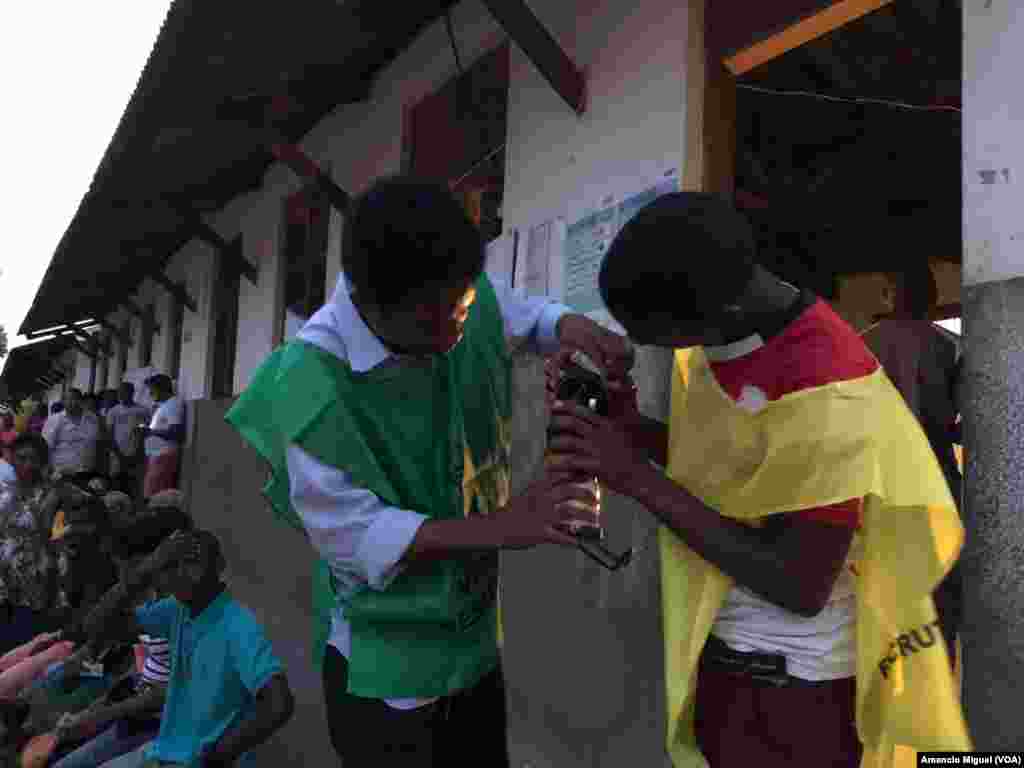 Dois funcion&#225;rios abastecem uma lamparina numa assembleia de voto em Wimby, Cabo Delgado. Mo&#231;ambique, 15 de Outubro, 2019