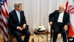 U.S. Secretary of State John Kerry, left, waits with Iranian Foreign Minister Mohammad Javad Zarif before a meeting in Geneva, Switzerland, Jan. 14, 2015. 