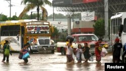 Habitantes de un barrio de Acapulco evacúan el lugar por temor a las inundaciones provocadas por la tormenta Manuel.